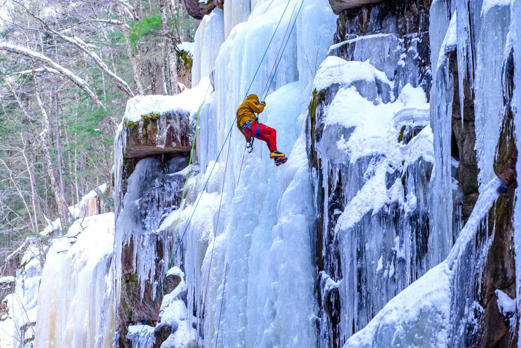 A man climbing up a frozen waterfall in Franconia, NH.