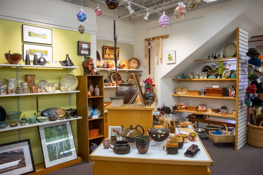 A gallery filled with handmade pottery, wooden boxes, jewelry, and trinkets.