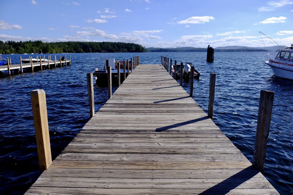 A wooden deck leading out to sapphire-blue water.