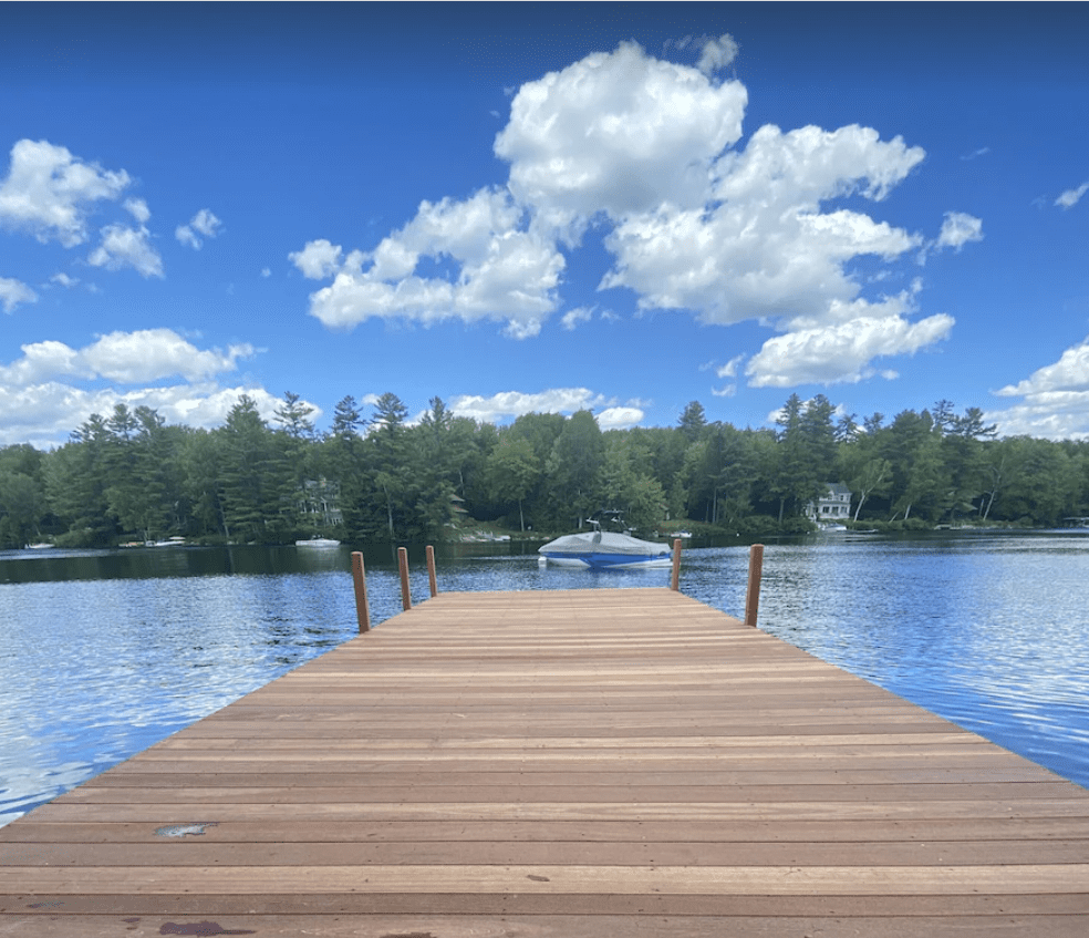 a photo of a wooden dock in Lake Sunapee with a clear blue sky