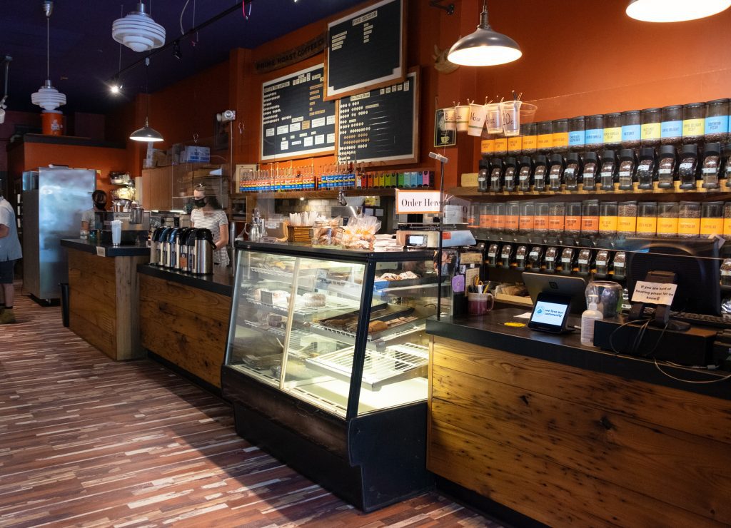 The interior of a coffee shop with about 24 different kinds of coffee available behind the counter.