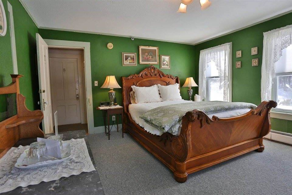 A hotel room painted green with antique furnishings