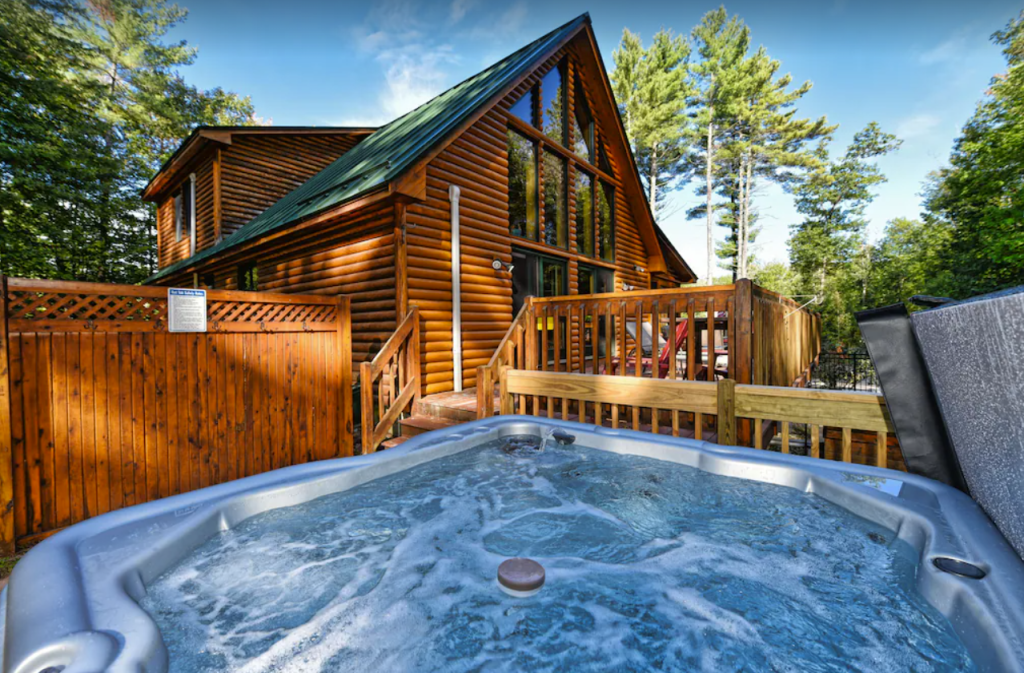 A bubbling hot tub in front of a luxury log home