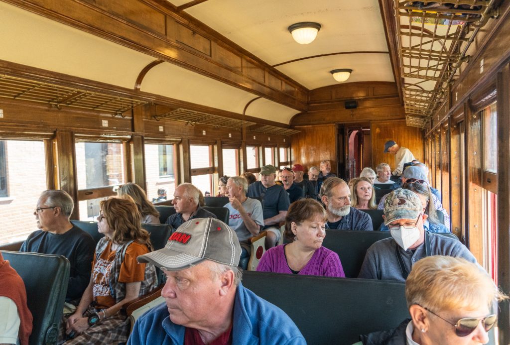 An old-fashioned train car filled to the brim with retirees.