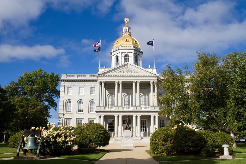 A stately granite building with columns and a gold dome.